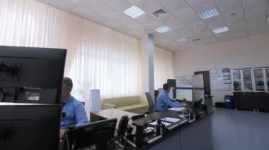 Mühendisler elektrik santralinin kontrol odasında çalışıyorlar.