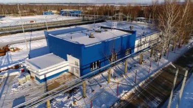 Atık su istasyonundaki havuzların yanında karlı çatılı atölye