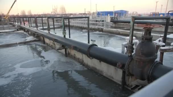 Tubería con palancas rojas cerca de cuenca con aguas residuales arremolinadas — Vídeo de stock