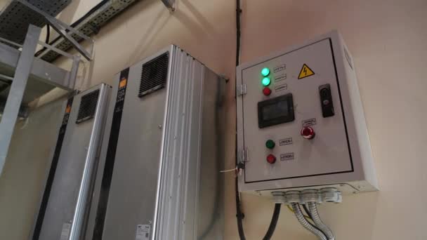 Green lights glow on switchboard cabinet door in workshop — стоковое видео