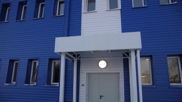 Gesloten toegangsdeur tot blauwe werkplaats met gloeilamp — Stockvideo