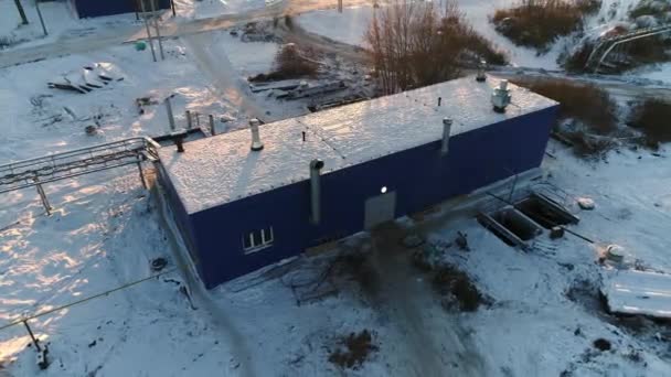 Byggnad med snöigt platt tak vid reningsverk — Stockvideo