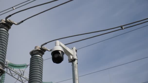 Bewakingscamera in de buurt van glas isolatoren op substation — Stockvideo