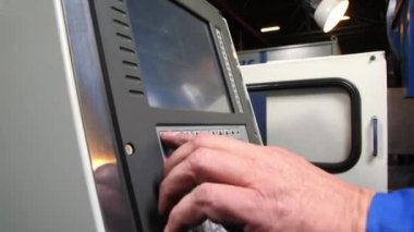 Olgun işçi otomatik makineyi çalıştırmak için tuşlara basar