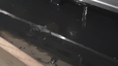 Su damlaları şeffaf sıvıyla kabın içine düşer.