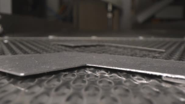 Cut metal details fall down on shaking conveyor belt — Stock Video