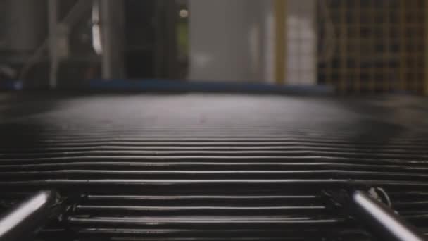 Пустой транспортер перемещается в полутемном цехе завода — стоковое видео