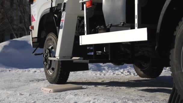 눈덮인 도로에 트럭 크레인의 수압 지지대 설치 — 비디오