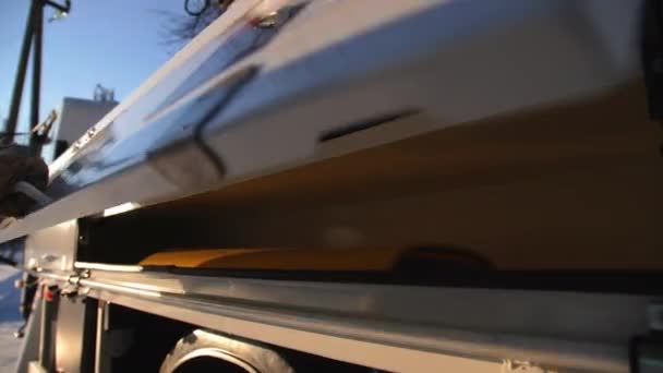 Opravář bere gumový plech z regálu na straně kamionu — Stock video