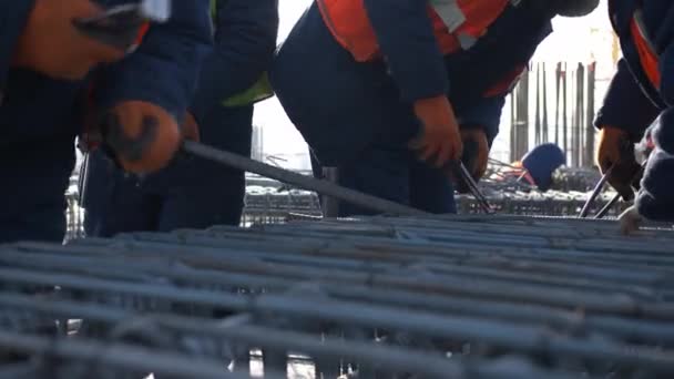 Gruppe von Arbeitern fertigt Metallkarkasse auf Baustelle — Stockvideo