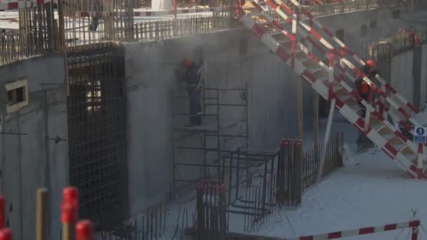 Constructor muele pared en andamios en el sitio de construcción — Vídeos de Stock