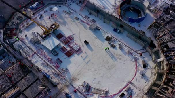 Snowy grond met werkende bouwers en machines bij zonsopgang — Stockvideo
