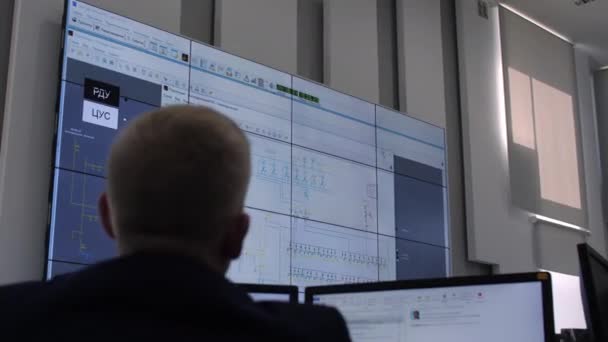 Engenheiro olha para monitor com esquema de conexão de equipamentos — Vídeo de Stock