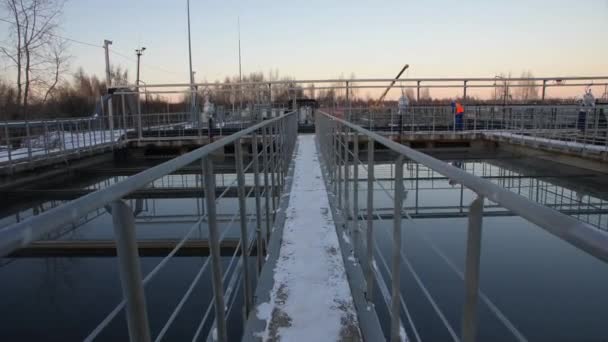 Puente nevado sobre el embalse con aguas residuales tranquilas en la estación — Vídeo de stock