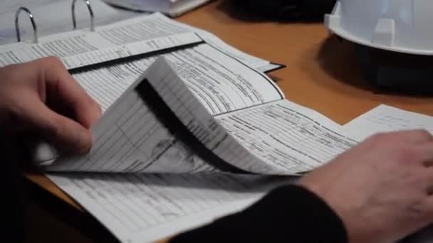 Сотрудник переворачивает страницы чтения документов за столом в офисе — стоковое видео