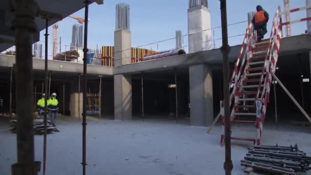 İnşaatçılar spor stadyumunun inşaat alanında yürürler — Stok video