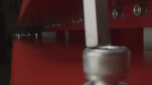 Arbeiter dreht Schraube an roter Kühlschranktür in Werkstatt — Stockvideo