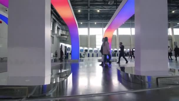 Visitors walk under colorful glowing led decorative arches — ストック動画
