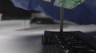 Çalışan, iş yerinde buzdolabının detaylarını birleştiren lambalar koyuyor.