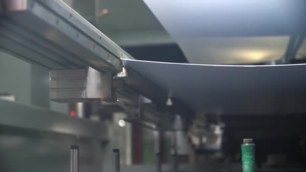 Maskinen sätter vit plastfolie på transportören i butiken — Stockvideo