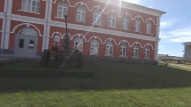 Ornate museum with old gun in yard near industrial complex — Stock Video