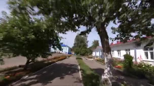 Bahnhofsgebäude und Blumenbeete an der Straße — Stockvideo