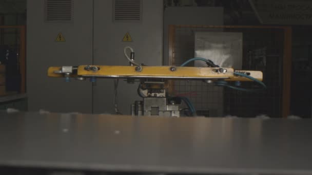 Маніпулятор з магнітами рухається, щоб взяти металевий лист на заводі — стокове відео