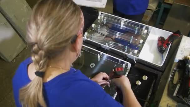 Señora y colega montan partes de refrigeradores en la planta — Vídeos de Stock