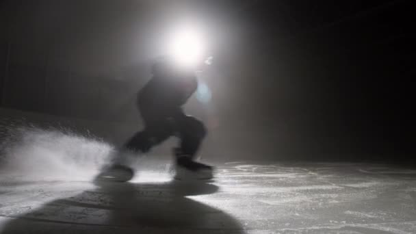 A jégkorong csapat résztvevőjének sziluettje korcsolyázás közben — Stock videók