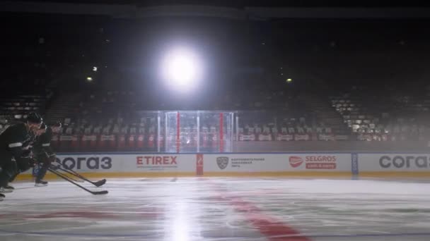 Hockey spelers in uniform met stokken schaatsen op de ijsbaan — Stockvideo
