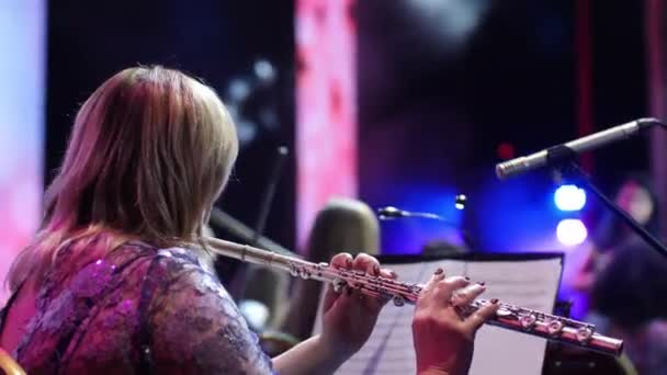 Femeie muzician cântă flaut cu orchestra în timpul concertului — Videoclip de stoc