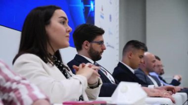 Genç uzmanlar masada oturup konferansa katılıyorlar.
