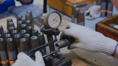 İşçi, masadaki mermiler için işyerlerini kontrol ediyor
