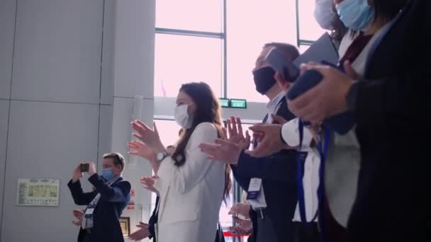 Persone con maschere mediche applausi al docente alla conferenza — Video Stock