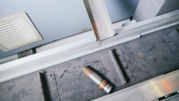 Proyectiles de balas se deslizan a lo largo de la cuneta para caer sobre el transportador — Vídeos de Stock