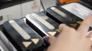 Kadın plastik tüpü kırmızı sıvıyla kabın içine koyuyor.