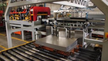 Otomatik üretim hattının yakınındaki metal levhalar yığını