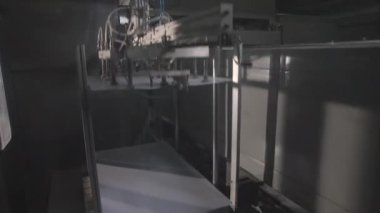 Mekanik kol otomatik taşıma bandına plastik levha koyar