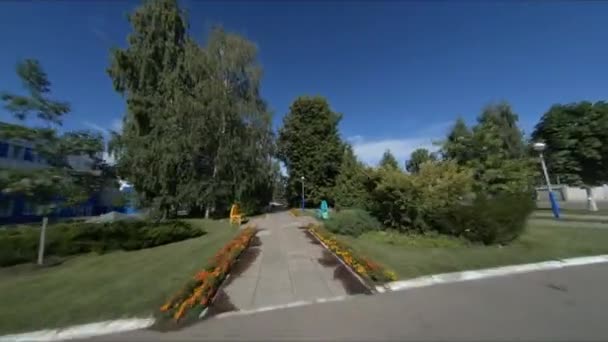 Movimiento a lo largo de la carretera del parque con tuberías rodeadas de casas — Vídeos de Stock