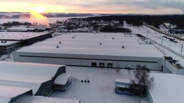 Karlı üretim kompleks bölgesinde düz çatılı bir depo.