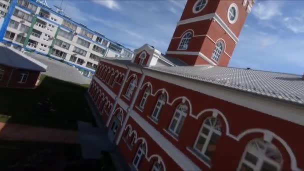 Altes rotes Gebäude mit Turm und Bogenfenstern in der Nähe der Anlage — Stockvideo