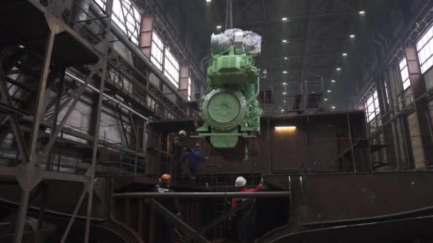 Employees group works installing ship motor in dry dock — Stock Video