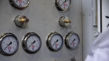 Mühendis atölyedeki kontrol panelinin kollarını metrenin altına çeviriyor.