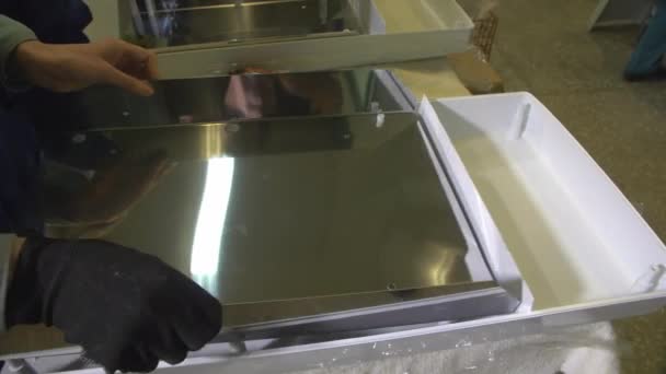 Trabajador pone detalle de metal en la caja de plástico en el taller — Vídeos de Stock