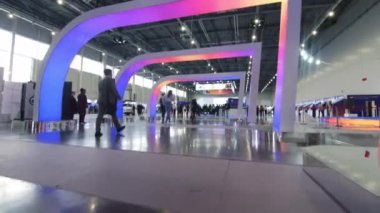 Ziyaretçiler parlak renkli ışıklarla kemerlerin altında yürür