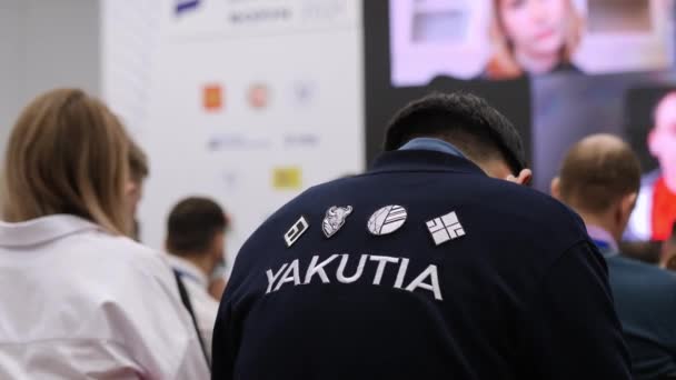 Man i jacka med ord Yakutia sitter på business forum — Stockvideo