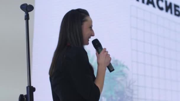 Леди бизнес-эксперт с микрофоном выполняет проект в холле — стоковое видео