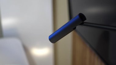 Oturma odasındaki TV 'nin yanındaki minimalist metal gece lambası. Aydınlatma ekipmanları evin içinde rahat bir atmosfer yaratıyor. Ev hayatı.