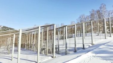 İnşaat alanının hava manzarasında karlı yamaçta bitmemiş bir metal leşi var. Kış ormanlarında inşa edilen çelik kirişlerin yapısı