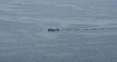 Kargo gemisi suyun üzerinde süzülüyor ve sakin ufukta durmaksızın uzanıyor. Sakin okyanus yavaş hareket eden geminin etrafında uzanıyor.